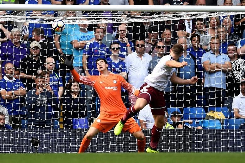 Two-goal hero Sam Vokes scoring Burnley's winning goal against Chelsea's Thibaut Courtois. Burnley won the Premier League match 3-2.