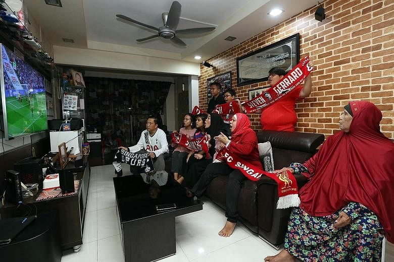 Masliah (second from right) and her family gather to watch Liverpool's Premier League opening match against Watford yesterday. Liverpool fans at the Four Points by Sheraton Singapore cheering after the Reds score against Watford.