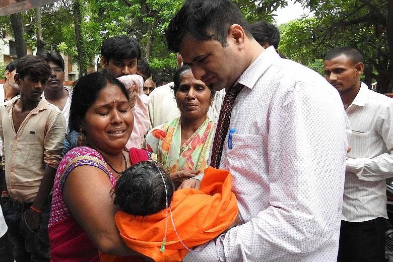 A woman with a child in her arms at the Baba Raghav Das Hospital in Gorakhpur, Uttar Pradesh, last Friday. All the deaths had occurred at the hospital's paediatric ward over a five-day period starting last Monday, said a statement from the chief mini