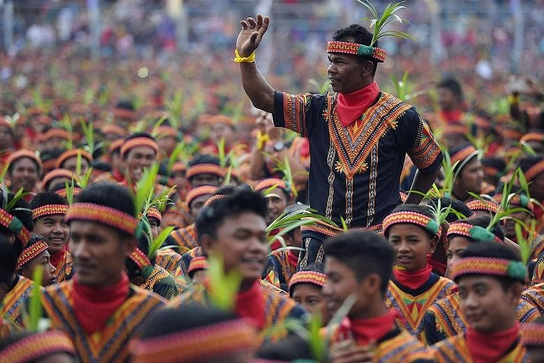 Men clad in elaborate traditional costumes at yesterday's event, which was aimed at attracting more visitors to the Indonesian province.