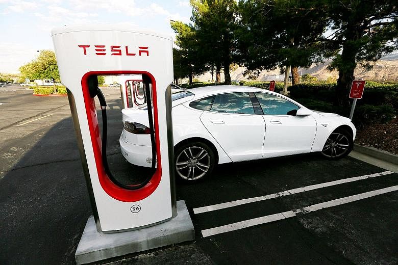 A Tesla Model S at a Tesla Supercharger station in Cabazon, California. The fleet of electric vehicles in use worldwide is on track to displace about 100,000 barrels a day of road transport fuel this year - most of it petrol.