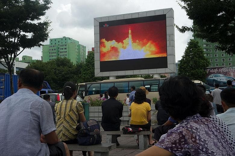 A North Korean ICBM missile test displayed on a screen in a public square in Pyongyang on July 29. According to US intelligence, Mr Kim Jong Un has achieved two things that experts had believed would take him five years: He has an intercontinental ba