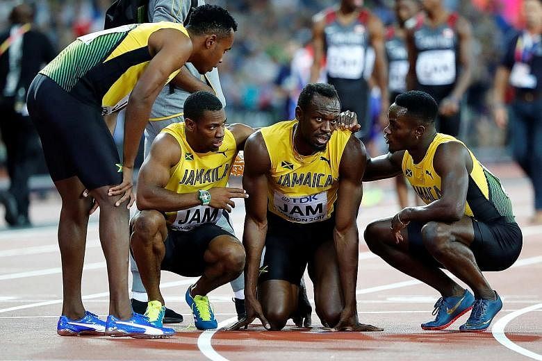 Jamaican star Usain Bolt is comforted by his teammates after suffering a hamstring injury during the 4x100m relay final - his swansong race.