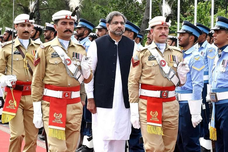 A Press Information Department photo released on Aug 3 shows Pakistani Prime Minister Shahid Khaqan Abbasi reviewing the honour guard during a welcome ceremony at Prime Minister House in Islamabad. Though he is loyal to ousted Prime Minister Nawaz Sh
