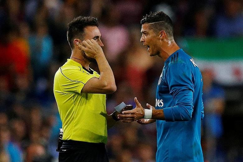 Far left: Cristiano Ronaldo mimicking Lionel Messi's El Clasico celebration and earning a caution after scoring Real Madrid's second goal against Barcelona in the Spanish Super Cup. Left: Ronaldo arguing with referee Ricardo de Burgos Bengoetxea afte