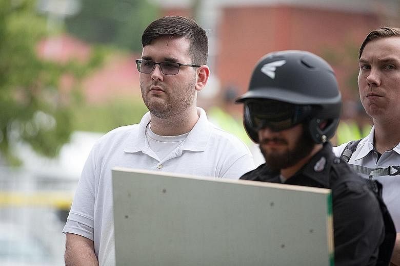 James Alex Fields Jr (far left) attending the "Unite the Right" rally in Emancipation Park in Virginia last Saturday, before he drove a car into a crowd later that day, killing one person and injuring 19 others.