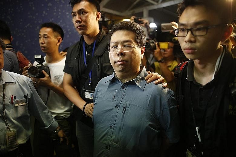 Opposition member Howard Lam was taken away by police in a van, in handcuffs on Monday morning. In a press conference last week, Lam displayed his stapled thighs.