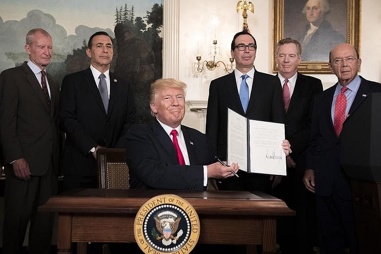 US President Donald Trump in the Diplomatic Reception Room of the White House on Monday with a signed memorandum calling for a trade investigation of China. With him are his inner circle who deal with trade issues, including Commerce Secretary Wilbur