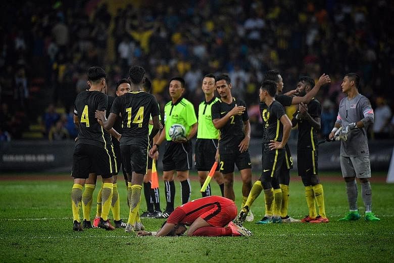 Singapore's Under-22 footballer Amiruldin Asraf slumped over in despair after hosts Malaysia came from behind to grab a 2-1 SEA Games group-stage win at the Shah Alam Stadium in Kuala Lumpur last night. It was the Young Lions' second straight loss at