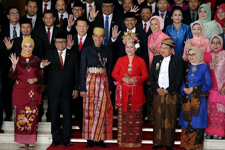 Indonesian President Joko Widodo and his wife, Iriana (centre), wearing traditional Bugis attire, together with Vice-President Jusuf Kalla and his wife, Mufidah (right), and lawmakers after Mr Joko delivered his annual address at the Parliament build