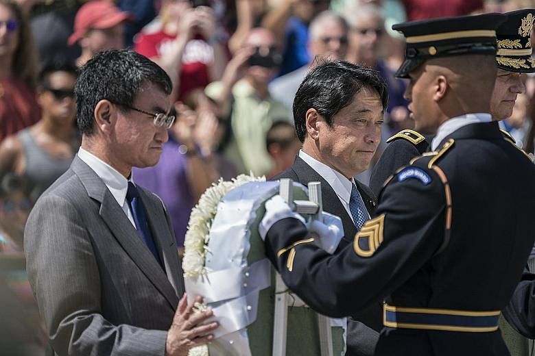 Foreign Minister Taro Kono (left) and Defence Minister Itsunori Onodera at a wreath-laying ceremony at Arlington National Cemetery in the US.