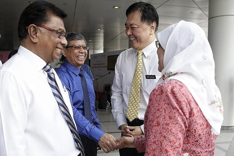 Madam Halimah Yacob and Mr Mohamed Salleh Marican exchanging a handshake at the launch of Singapore's first milk bank yesterday. With them are Temasek Foundation Cares chairman Richard Magnus (far left) and KKH chief executive Alex Sia.