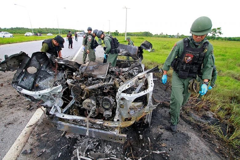 Military personnel searching the site of a bomb blast in the southern province of Pattani, Thailand, on Wednesday. A car exploded on a rural road, prompting an exchange of gunfire, said police.
