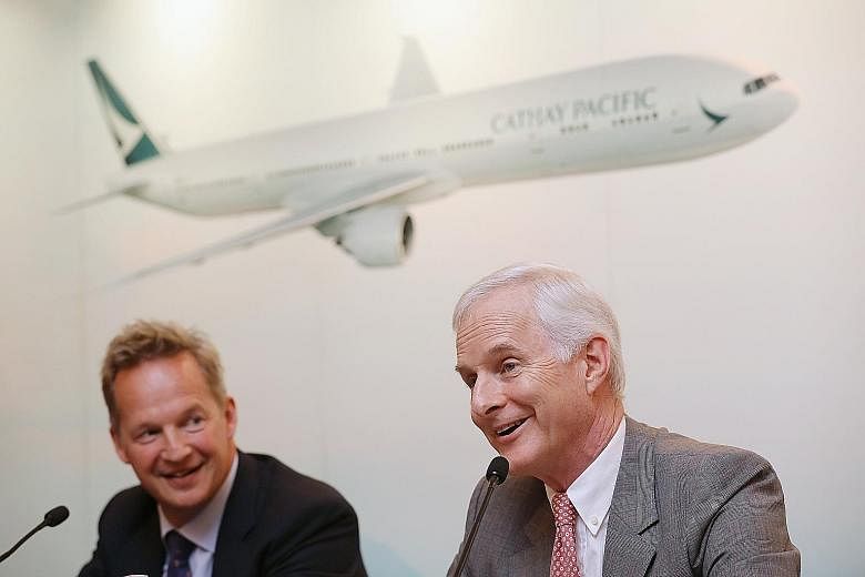 Cathay Pacific's chairman John Slosar (right) and CEO Rupert Hogg at a conference in Hong Kong on Wednesday. The airline reported a net loss of HK$2.05 billion (S$360 million) for the six months to June.