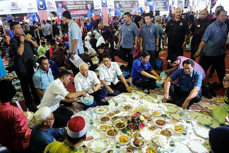 Malaysian Prime Minister Najib Razak (in white, washing his hand) at a feast held yesterday in Permatang Pauh, the stronghold constituency of jailed opposition leader Anwar Ibrahim, where he kicked off a charm offensive in the Northern Corridor Econo