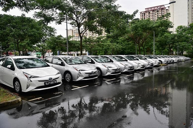 All spruced up and nowhere to go - a new fleet of private-hire Toyota Priuses lined up in a carpark in Holland Village waiting for hirers.