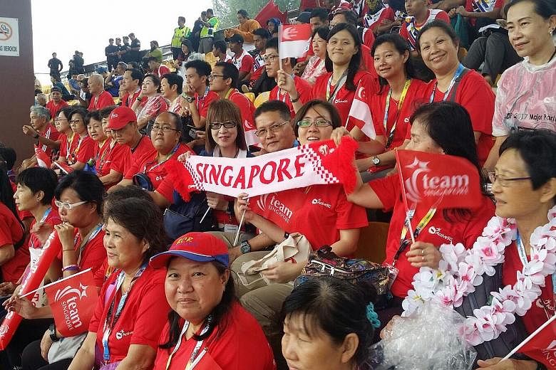 Team Singapore supporters watching the football match between Singapore and Laos yesterday. They are on the ActiveSG Experience Tour.