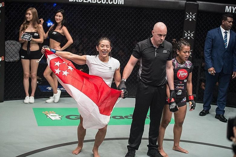 May Ooi holds up the Singapore flag after beating home favourite Ann Osman at One Championship's Quest for Greatness event at the Stadium Negara in Kuala Lumpur.