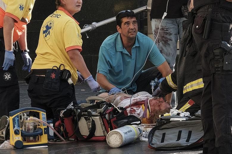 Paramedics attending to one of the many pedestrians struck by a van that ploughed into crowds in Las Ramblas, Barcelona's most famous street, on Thursday. At least 13 people were killed and 130 injured in the terror attack, which residents had long f