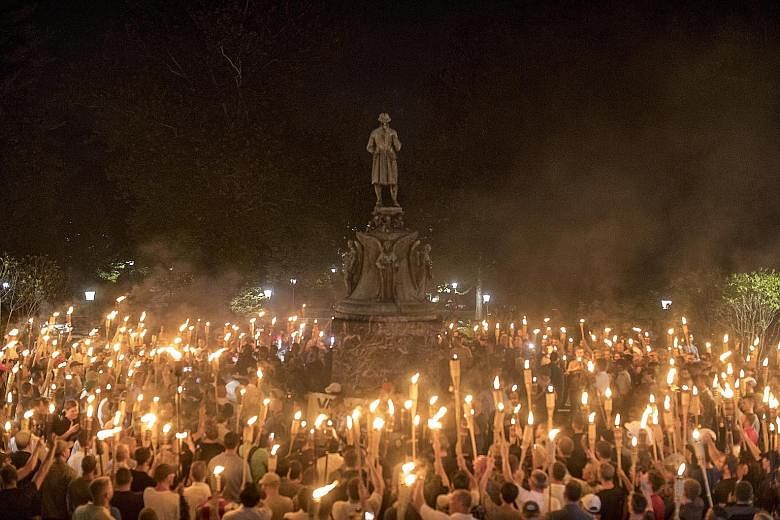 Torch-bearing white nationalists rallying around a statue of Thomas Jefferson near the University of Virginia campus in Charlottesville on Aug 11. The white nationalists - unlike neo-Nazis in Europe and Al-Qaeda and ISIS militants who cover their fac
