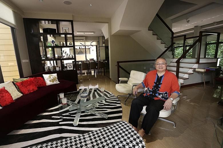 Former group chief financial officer of Neptune Orient Lines Lim How Teck in his living room, where he enjoys entertaining guests. The wall dividing the two houses was removed to open into another dining area. He moved into the cluster housing develo