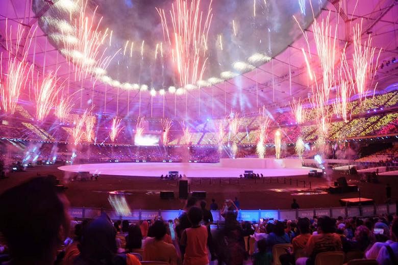 Fireworks; the performers including wushu exponents and traditional dancers; and the Singapore contingent, led by shooter Jasmine Ser, walking out during the athletes' parade at the Bukit Jalil National Stadium yesterday.