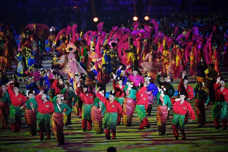 Clockwise from top: Fireworks; the performers including wushu exponents and traditional dancers; and the Singapore contingent, led by shooter Jasmine Ser, walking out during the athletes' parade at the Bukit Jalil National Stadium yesterday.