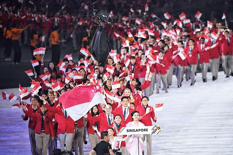 Clockwise from top: Fireworks; the performers including wushu exponents and traditional dancers; and the Singapore contingent, led by shooter Jasmine Ser, walking out during the athletes' parade at the Bukit Jalil National Stadium yesterday.