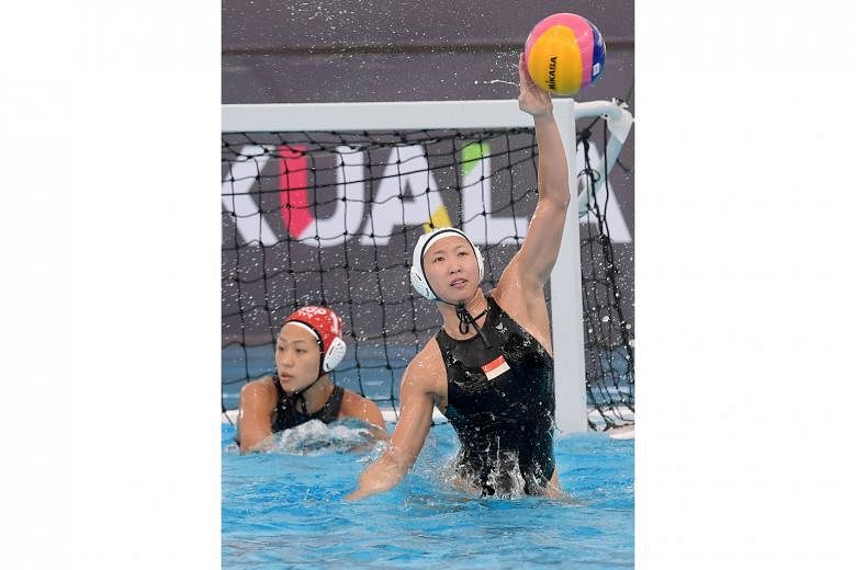 Singapore's Angeline Teo rises to block a shot from Thailand during the SEA Games women's water polo competition at Bukit Jalil's National Aquatic Centre. Teo scored to make it 1-1 before the Thais ran away with a 5-1 win.