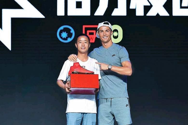 Mr Lyu Shaowu with Cristiano Ronaldo, who gave the primary school teacher a pair of his boots. Mr Lyu's dedication in teaching more than 30 pupils football on a wasteland at his school in Gansu province's Longxi county has drawn focus to his little-k