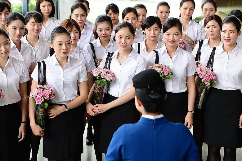 China's XiamenAir unveiling its first batch of Taiwanese cabin crew last Wednesday. China is wooing youth from the island in what analysts say is a "soft power" push to sway political sentiment.