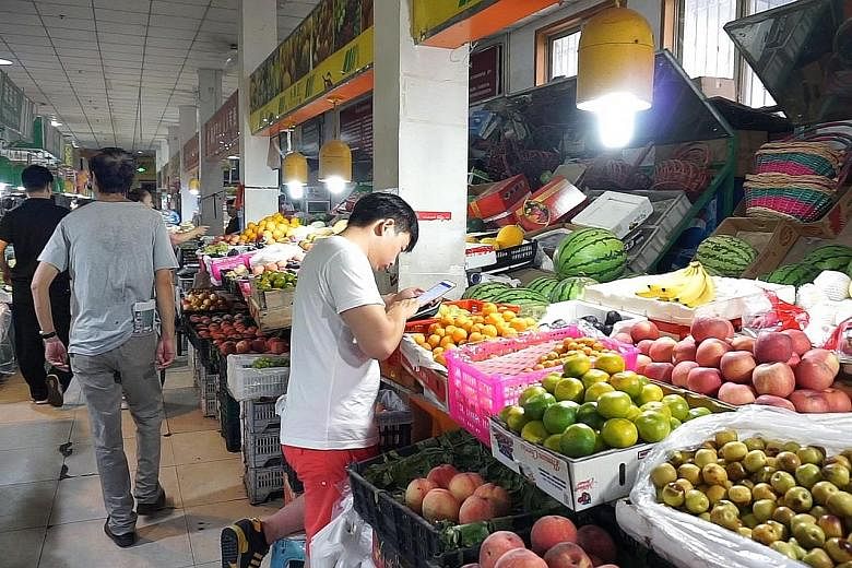 In major Chinese cities, cashless payments - including at hawkers and fruit sellers like this in Beijing - are normal.