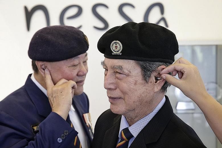 Lt-Col (Ret) Bob Cheah (far right) and Col (Ret) Lau Kee Siong have been using these barely visible hearing aids from nessa Asia for up to two years. Exposure to loud sounds made hearing loss an occupational hazard for SAF veterans.