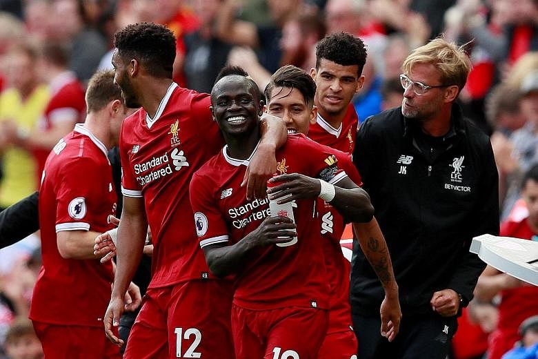 Liverpool forward Sadio Mane (centre) celebrating his winner with Liverpool manager Jurgen Klopp (right) and his team-mates.