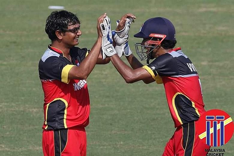 Off-spinner Dharmichand Mulewa (left), who took 7-22 against Myanmar, congratulated by wicket-keeper Vivek Vedagiri.