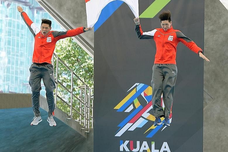 SEA Games water polo debutants Chow Jing Lun (left) and Yu Junjie jumping from the diving platform while holding the Singapore flag after winning the gold at Kuala Lumpur's National Aquatic Centre. It is a tradition for players making their Games bow