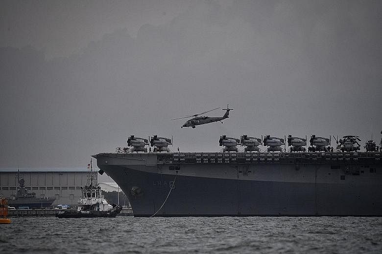 Above: The amphibious assault ship USS America, which is now in Changi, will provide messing and berthing services to the crew of the USS John S. McCain and support damage control efforts on board, the US 7th Fleet said late yesterday. Below: The USS