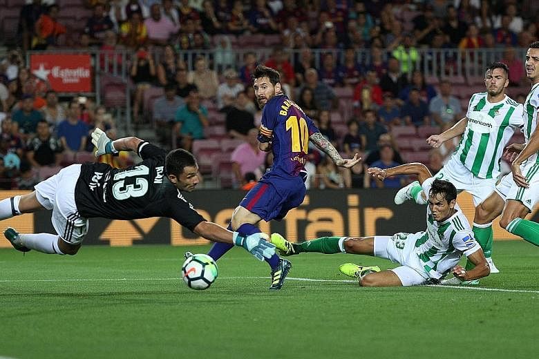 Barcelona skipper for the day Lionel Messi scoring his side's first goal past Real Betis goalkeeper Antonio Adan in their La Liga opener, a 2-0 win at the Nou Camp on Sunday. Last season's runners-up, playing for the first time after the terror attac