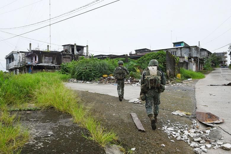 Philippine troops patrolling a deserted neighbourhood in Marawi last month. Dozens of militants remain holed up in the city.