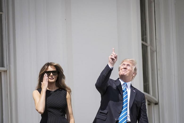 Eclipse-viewing in New York. Americans were gripped by the Sun vanishing behind the Moon in an unusual coast-to-coast event. US President Donald Trump looking up at the eclipse without protection, while First Lady Melania wears special glasses at the