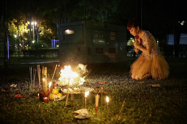 Getai singer Yuan Jin burning joss paper before she takes the stage at a getai performance at an open field in Yung An Road. The Hungry Ghost Festival, which takes place in the seventh month of the lunar calendar, officially started on Tuesday. Durin