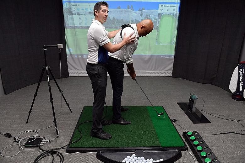 GolfTEC Singapore centre manager Craig Crandall demonstrating how GolfTEC's motion measurement technology works to improve a golfer's swing, with Pro Golf Asia executive director Abhinav Gorawara acting as a student. The Republic Plaza II facility is