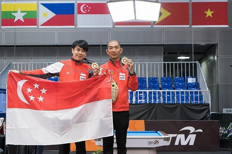 Above: Chan Keng Kwang (left) and Tey Choon Kiat hold up their gold medals after defeating their Thai opponents in the snooker doubles final. Left: Tey lining up a shot in the final. The 49-year-old said experiences in previous Games helped the pair 