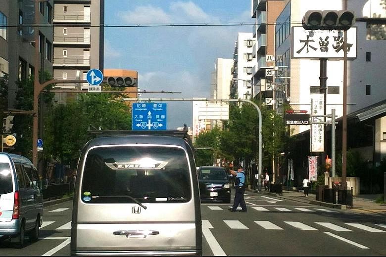 Traffic lights went black at several major intersections in Osaka yesterday during the nearly 12-hour-long blackout that affected homes, hospitals and supermarkets as well. Train systems, however, were unaffected as they use a separate power network.