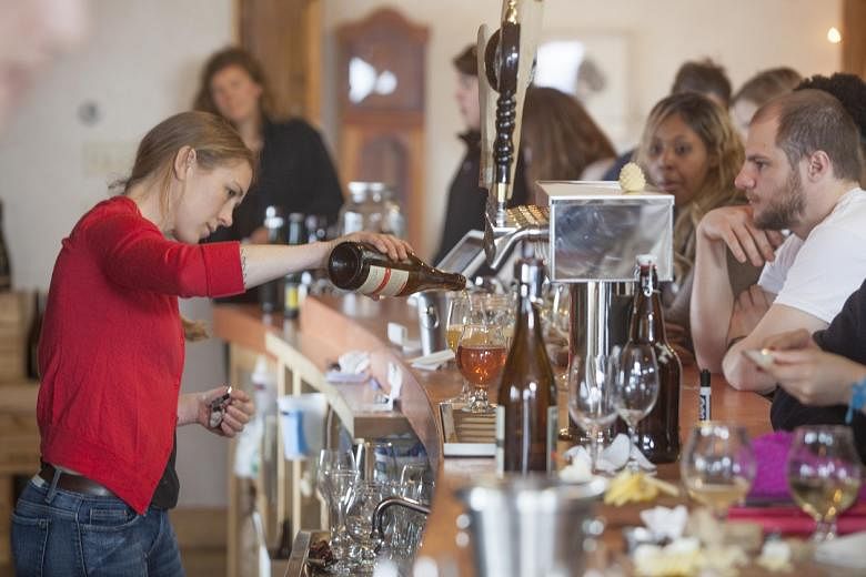 Ms Melissa Madden pours a customer's drink at Finger Lakes Cider House in Interlaken, New York, in March 2017. 
