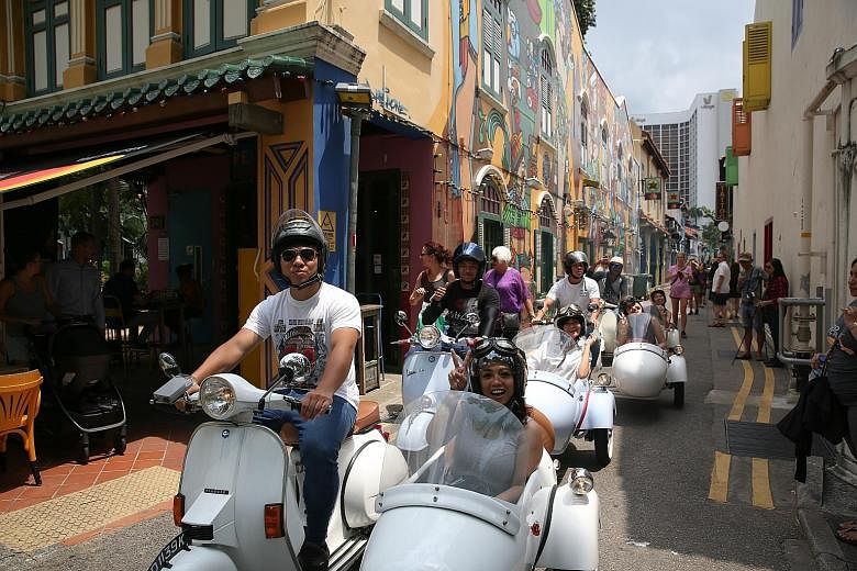 Philippine tourist Mary Grace Lucero on a Vespa tour of Kampong Glam yesterday. Among the new tours on offer are Vespa rides in locations such as Joo Chiat and Little India, as well as a walking tour of next-generation hawkers.