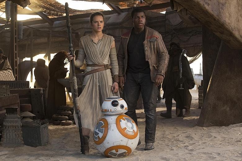 John Boyega (with Daisy Ridley and droid BB-8) in Star Wars: The Force Awakens.