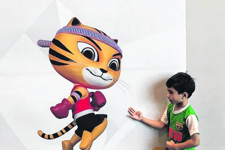 Imitating a Muay Thai stance by the Games mascot, Rimau, appears to give this young Barcelona fan a kick out of spectating at the Games. From left: Singapore athletes Nur Izlyn Zaini, Wendy Enn, Goh Chui Ling, Shanti Pereira, Dipna Lim-Prasad, and Ku