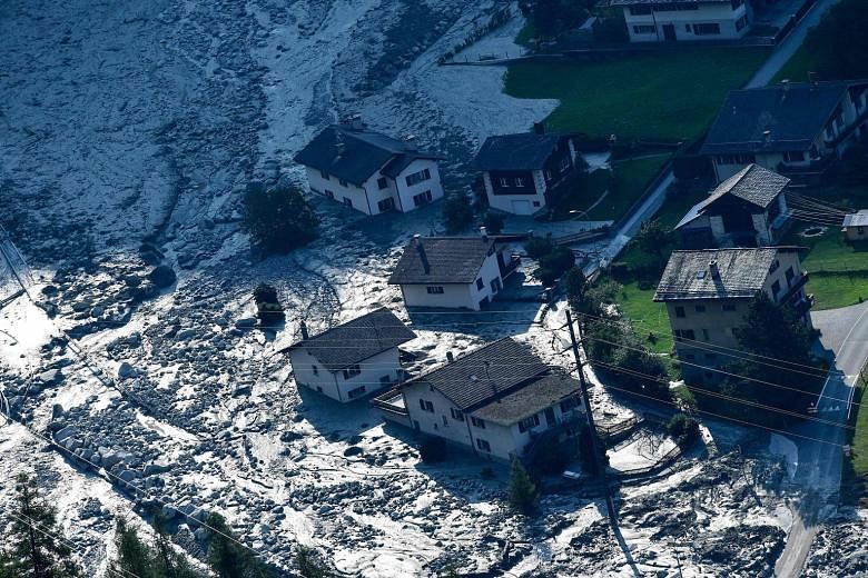 This photograph taken yesterday shows the mass of rocks and mud that slammed into buildings in the Swiss Alps village of Bondo two days earlier. A search and rescue operation is under way for the eight missing people who were hiking in the Val Bondas