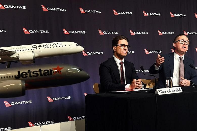 Qantas chief executive officer Alan Joyce (at right in photo) and chief financial officer Tino La Spina at a press conference for the company's full-year results announcement in Sydney yesterday. The company's domestic arm reported a record underlyin